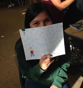 Monique, a 10th grade student in Orphal's Intro to Education class, holds up the children's book she wrote.