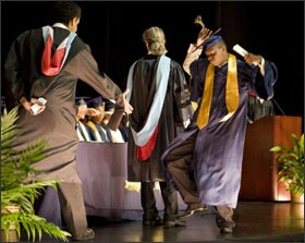 Charles Woods III dances on stage after receiving his diploma at graduation ceremonies.