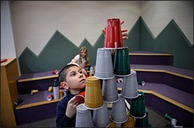 Second grader Frank Pranzo builds a pyramid from plastic cups as part of a SHINE activity.
