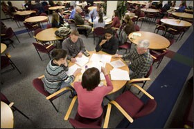 Teachers meet in teams in the cafeteria before classes at Adlai E. Stevenson High School.