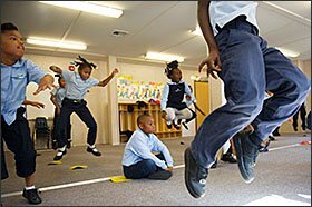 Jerome Brewer, center, a 2nd grader at Memphis College Prep, sits while his classmates participate in a physical education class.