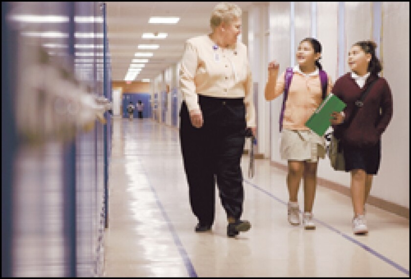 Judy Meyer, the principal of David G. Burnet Elementary School, walks with Rocio Sanchez, 9, center, and Carolina Cabrera, 10. Some elementary principals will be required to study Spanish.