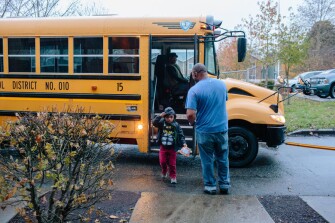 Bobby Gantt greets his 5-year-old son, Jason Gantt, as a bus drops him off from after kindergarten class school in Tacoma, Wash.
