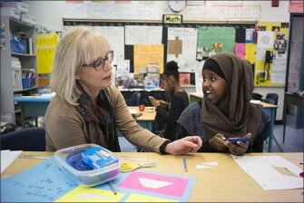 Teacher Ann Woomert work with Aisha, 12, from Somalia, in an ESL/ELL class at Islington Junior High School.