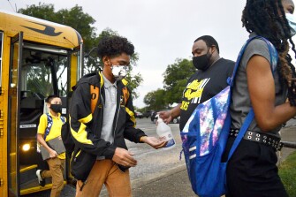 Orchard Knob Middle School Assistant Principal Michael Calloway squirts sanitizer onto students hands as they arrive for the first day of school at Orchard Knob Middle School, in Chattanooga, Tenn., on Thursday, Aug. 12, 2021.