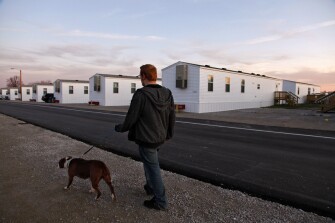 Freshman Greg Lamp, walks his dog, Belle Starr, near the trailer provided by the Federal Emergency Management Agency that his family moved into after the tornado. As many as 500 students districtwide are still living in trailers provided by FEMA.