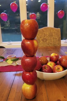 Guests at Olivia Aston’s teacher shower competed to stack six apples on top of each other.