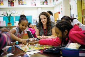 Catherine Riede, a City Connects coordinator at Josiah Quincy Elementary School, in Boston, watches as students play a game of Candyland as an ice-breaker exercise. A recent study found that the academic gains students made in the program persisted into middle school.