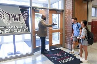 Principal Michael C. Brown, from left, talks to seniors Brady D’Anthony, 18, and Sydney Dryden, 17, at Winters Mill High School in Westminster, Md., Tuesday, May 17, 2022.