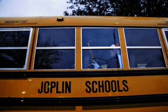 Senior Aidan Shipley, of the Joplin High School band, waits on a bus before the Christmas parade in downtown Joplin.