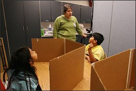 English-as-a-second-language teacher Coral Russell talks with 3rd graders Leslie Oxlaj, left, and Kevin Guzman before standardized testing at Columbian Elementary School in Carthage, Mo.
