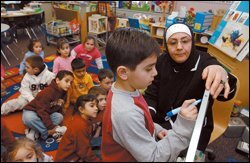 Niyaz Chahine helps Becker kindergartner Kasem Chami with an Arabic writing exercise.