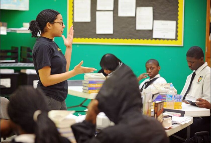 Yasmene Mumby, left, teaches an 8th grade social studies class at Ujima Village Academy Elementary/Middle School, one of two schools operated by KIPP Baltimore. Teachers' work hours have been at the center of a dispute between KIPP and the Baltimore Teachers' Union.