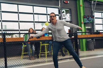 Teacher Beth Defebaugh plays pickle ball at Chicken and Pickle in Wichita, Kansas, during a teacher field trip meant to show teachers real world applications for learning.
