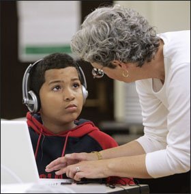 Julie Bertram, a Boston University project manager, helps 6th grader Randolph Alvarez Abreu during a diagnostic reading test at Patrick F. Gavin Middle School in Boston, where scholars with the Strategic Education Research Partnership are working.