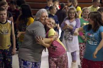 Third grade teacher Debbie Damron hugs a former student of hers, 5th grader Hailey Mitchem, 11, during a dance party to reward students for good behavior. Ms. Damron is one of several teachers at Iaeger Elementary retiring at the end of this year.