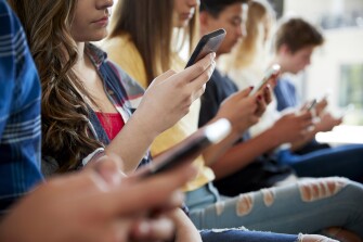 Image of a group of teens using their mobile devices.