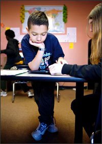 Eleven-year-old Chance Connors helps classmate Jessica Ramsey, 14, work on a writing tutorial on one of the Apple iPads in their classroom at High Road Academy of Baltimore County, West, in Dundalk, Md. Tablet computers are becoming a popular assistive-learning device in special education programs across the country. When Chance uses the iPad, he likes to practice his mathematics skills with the Math Ninja application.