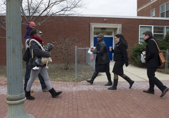 Mills and Bakker walk to the bus stop to take their children Emily and Blake to daycare.