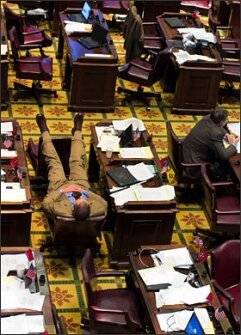 Rep. Andy Holt, of Dresden, rests at his desk while fellow Republican Rep. Harry Brooks, right, of Knoxville, reads during a lull on the House floor on May 20 in Nashville, Tenn. Legislators considered a bill that would replace teachers’ collective bargaining rights with a concept called collaborative conferencing. The measure was later adopted by the Senate.