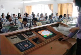 A teacher at the Experimental High School in Zhuhai uses a monitor inset of a multimedia station to change an overhead screen.
