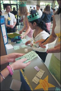 Campers at "Washington Business Week" in Spokane count the simulated "investments" they have attracted for their concept for a robotic lawn mower.