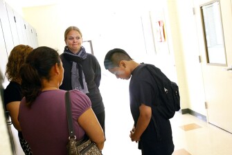Danny Perez, a 7th grader at Davidson Middle School in San Rafael, Calif., waits in the hallway with assistant principal Kristy Treewater, center, his mother Ofelia Ajeatas, and a translator while the peer court deliberates his fate.