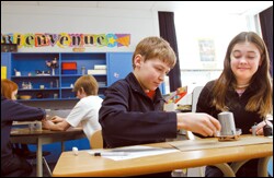 Daniel Boissonneau-Lehner, center, and Spence Colburn, both 12, work on a science project using French at the McKernan School.