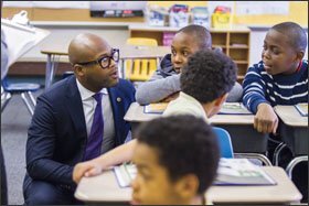 Mr. Dickey, left, discusses a literacy lesson with Mekhi Hardy, 9, center, and Robert Adside, 10, right, during a 4th grade class at William Dick School in North Philadelphia. The CAO plans to teach at least three demonstration lessons in elementary, middle, and high schools this year.