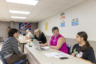 Mentor Caitlyn Crews works with students during an after school program at Mountain Education Charter High School in Woodstock, Ga. The Mountain Education Charter High School system has a program that pairs struggling students with adults who have faced similar challenges.