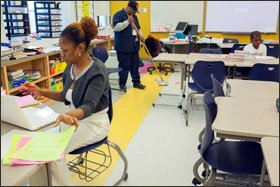 Dowan McNair-Lee grades homework after school at Stuart-Hobson while her son, Courtland, works on his own homework. The veteran teacher stays at school through later afternoon and often takes work home to do in the evenings.