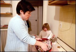 Shelley Midura and her daughter, Sophie, wrap homemade pralines to use as goodbye gifts before the family's return to New Orleans. Midura needs to find a new school for two of her three children because their charter school was forced by the hurricane to relocate to another community.