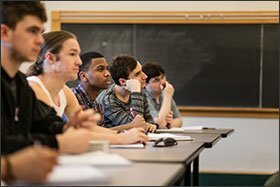 Barnes, center, takes notes during a lecture on economic discrimination during his Labor Economics class at Grinnell.