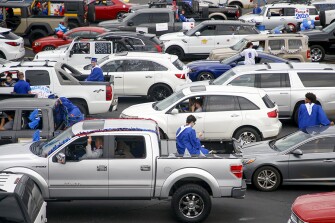 Seniors sit on their cars and talk to classmates while waiting for the start of a graduation parade for Bixby High School’s class of 2020 on Thursday, May 7, 2020.