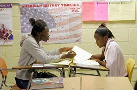 Kingstree Junior High School students Shanice Gamble, left, and Kierra Greene help each other with classwork.