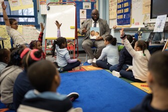 Chimere Stephens, the Director of NYC Men Teach at the NYC Department of Education, reads a book to a class of first grade students at PS 55 elementary school in the Bronx, New York, January 19, 2023.