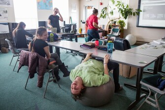 Sixteen-year-old Bridget, right, stretches out on an exercise ball during science class while beside her, classmate Nicole, 17, looks on. Students are encouraged to sit where they feel comfortable, and often times that may mean sitting on a desk, on the floor or on an exercise ball. “I had to get used to not being distracted by their coping skills,” recalled Alisa Tracy, an English and special education teacher. “One student learned best by sitting on the table by the window and staring out the window. Make her sit in a desk, she’s so anxious, can’t concentrate … but she could sit on the table with her notebook and just absorb everything; you ask her any random question and she would give completely thoughtful answers.”