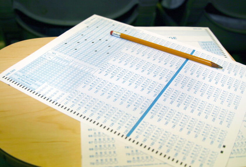 Standardized test answer sheet on school desk.