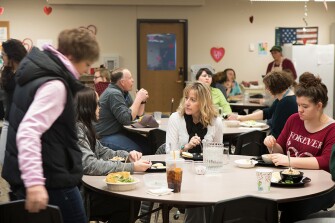 School Principal Dixie Cooper, center, eats lunch with 15-year-old students Emily, sitting left, and Kaitlyn.