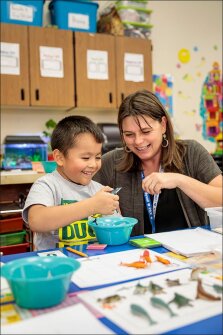 First grader Logan Kneeland works on a math exercise with teacher Shannon Mode at Willamina Elementary School in Willamina, Ore. The school has partnered with local tribes to lower rates of absence among its Native American students.