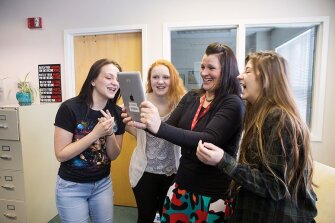 The Girls School was among the first juvenile facilities in the country to adopt 1-to-1 tablets and smart boards, and teachers and administrators say technology has dramatically changed what courses and academic projects the school can offer students. From left, 18-year-old students Willow and Bailey, technology and psychology teacher Michelle Nielsen, and student Addie, 18, take photos of each other to explore works of art on the Google Arts and Culture Face Match during technology class.