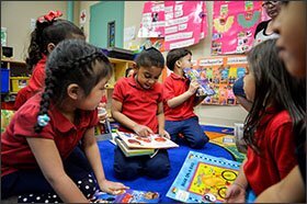 Students in Elizabeth Chico’s prekindergarten class read books on the carpet at Rising Stars APM Preschool in North Philadelphia.
