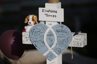 Eliahana Torres' cross stands at a memorial site for the victims killed in this week's shooting at Robb Elementary School in Uvalde, Texas, Friday, May 27, 2022.