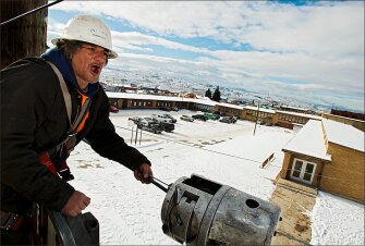 Val Anderson hollers orders to a crew member while they install fiber-optic cable at the Butte High School Career Center in Montana. The new fiber-optic network will deliver faster Internet connections to 12 city school buildings.