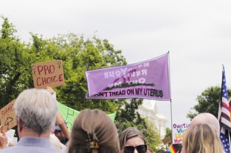 A "Don't Tread On My Uterus" flag waves amongst the crowd of protesters outside the Supreme Court on June 24, 2022.
