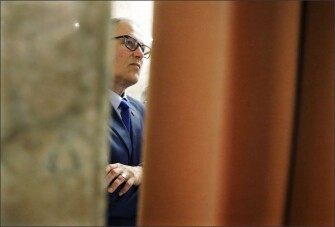 Washington Gov. Jay Inslee watches from the wings of the House chamber during debate on the state operating budget at the state Capitol in Olympia, Wash., on June 30. The Washington Legislature approved a new two-year state operating budget Friday, sending the spending plan to Inslee in time to avert a partial government shutdown.