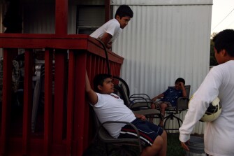 Juan Pablo Pacheco, center, hangs out with friends after playing basketball with a soccer ball.