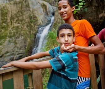 A young Dominican alerts his friend to the photographer’s presence near the Jimenoa Waterfall near La Joya, Jarabacoa.