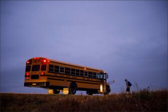 A student boards an early-morning school bus on the Pine Ridge reservation. Long bus rides are common for students who live outside the main population centers on the 3,500-square-mile reservation.