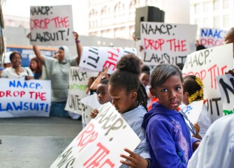 Charter school students, draped in oversize T-shirts that read "Future NAACP Members," are joined by parents and teachers at a protest rally May 26. The demonstrators want the NAACP to withdraw from a lawsuit against the expansion of charter schools across New York City.